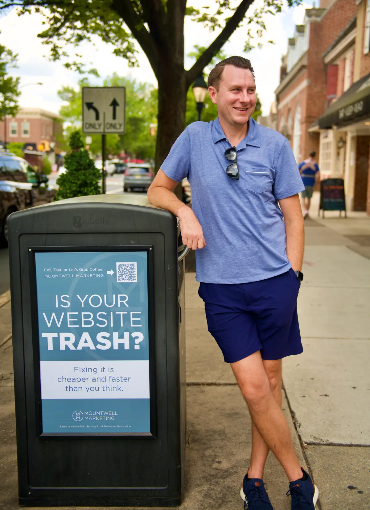 Lee Procida leaning on a street trash can with a Mountwell ad that asks, Is your website trash?